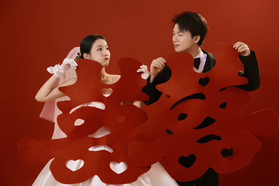 Lin 和 Wu 手持囍字的红色主题合影